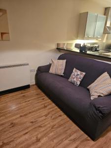 a black couch in a room with a kitchen at Penthouse Apartment in Kilkenny