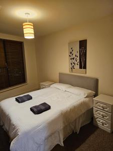een slaapkamer met een bed met twee handdoeken erop bij Penthouse Apartment in Kilkenny