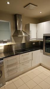 a kitchen with white cabinets and a stove top oven at Penthouse Apartment in Kilkenny