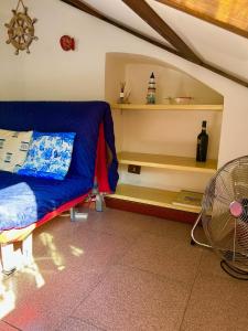 1 dormitorio con 1 cama azul y ventilador en Ca' Berio 67 en Imperia