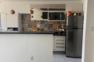 uma cozinha com um frigorífico e um micro-ondas em Apartamento bossa nova em Aracaju
