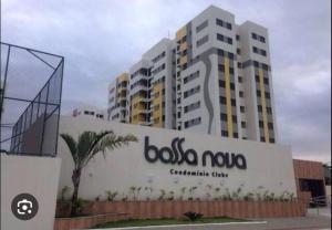 um grande edifício com uma placa em frente em Apartamento bossa nova em Aracaju