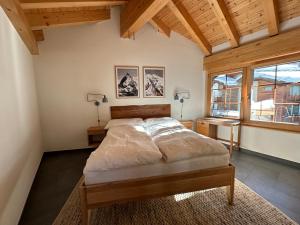 1 dormitorio con 1 cama grande, 2 lámparas y ventana en Modern apartment with stunning village and Matterhorn views, en Zermatt