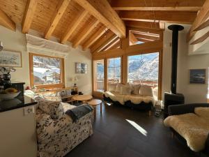 sala de estar con sofás y ventana grande en Modern apartment with stunning village and Matterhorn views, en Zermatt
