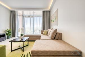 a living room with a couch and a table at Luxury 1BR at DAMAC Celestia A Dubai South by Deluxe Holiday Homes in Dubai