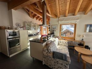 sala de estar con sofá y cocina en Modern apartment with stunning village and Matterhorn views, en Zermatt