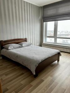 a bedroom with a bed and a large window at Апартаменти Парус біля Вікторії Гарденс, Південого in Lviv