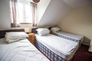 two twin beds in a small room with a window at Seaside Cottage In Beautiful Hemsby, Norfolk By The Beach Ref 99007j in Hemsby