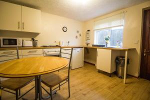 a kitchen with a table and a table and chairs at Seaside Cottage In Beautiful Hemsby, Norfolk By The Beach Ref 99007j in Hemsby