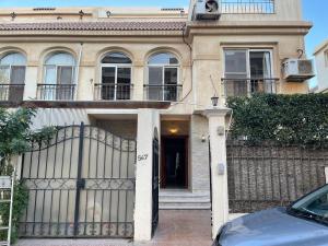 a house with a gate and a car parked in front at Charming Villa in Sheikh Zayed