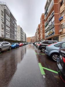 a wet street with cars parked in a parking lot at aparment la Elipa in Madrid