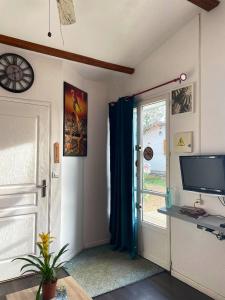 a room with a door with a television and a window at Studio avec jardin clos et wifi a Durtal in Durtal