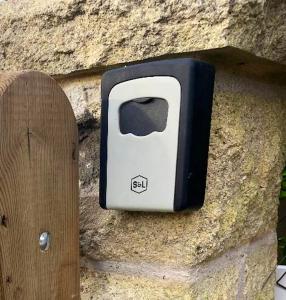 un aparato blanco y negro en una pared de piedra en Studio avec jardin clos et wifi a Durtal, en Durtal