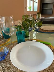 - une assiette blanche sur une table avec des verres à vin dans l'établissement Borgo24 family vacation Florence, à Lastra a Signa