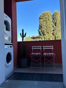 un balcon avec deux tabourets et un lave-linge dans l'établissement Borgo24 family vacation Florence, à Lastra a Signa