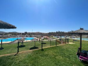 a resort with a pool and a playground with umbrellas at La casa de las piedras 