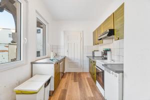 una cucina bianca con pavimenti in legno ed elettrodomestici bianchi di MONTEURWOHNUNG in Lorch RAUMSCHMIDE Apartments a Lorch
