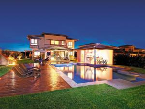 a house with a swimming pool in front of a house at Quintas Private Residence in Costa do Sauipe