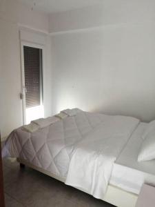 a white bed in a white bedroom with a window at Cozy Rodas House 2 in Politika