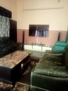 salon z kanapą i stołem w obiekcie CRYSTAL SUITES w Akure