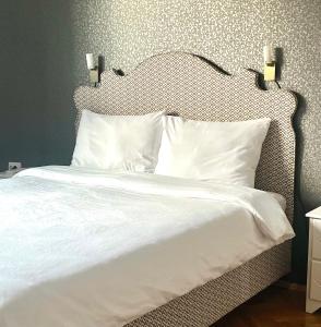 - un lit avec des draps et des oreillers blancs dans une chambre dans l'établissement Super Center, à Stara Zagora