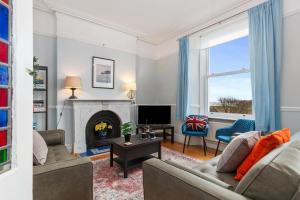 a living room with a couch and a fireplace at Penalun House - Beautiful Sea Views in Penally