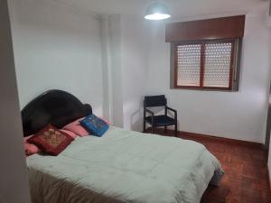 1 dormitorio con 1 cama, 1 silla y 1 ventana en Espacio Belgrano departamento centrico en Salta