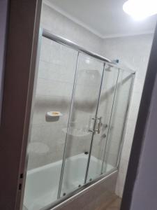 y baño con ducha y puerta de cristal. en Espacio Belgrano departamento centrico en Salta