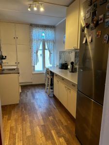 a kitchen with a stainless steel refrigerator and wooden floors at Family Apartment near Kadriorg Swan Pond in Tallinn