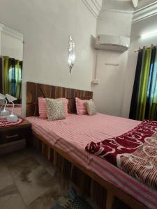 a bedroom with a large bed with pink pillows at Naari home stay in Mathura
