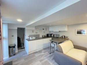 a living room with a couch and a kitchen at 10 Bromleys Court in Church Stretton