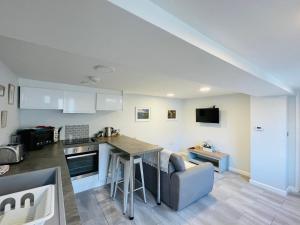 a kitchen and living room with a table and a couch at 10 Bromleys Court in Church Stretton