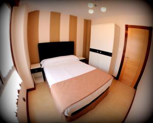 a small bedroom with a bed and a cabinet at Apartaments La Reserva Premium in Noja