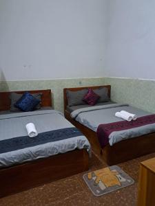 a room with two beds with towels on them at Guesthouse Chamroeun Mongkul in Kampot