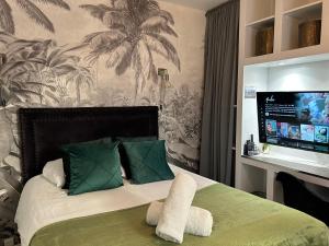 a bedroom with a bed with a tv on the wall at Appart'TERRASSE - 20mn STADE U ARENA - CHAMPS ÉLYSÉES - BEST PLACE JO 2024 in Maisons-Laffitte