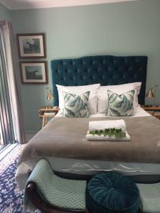 a bedroom with a large bed with a blue headboard at Lucano 1 Stellenbosch in Stellenbosch