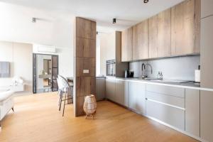 a kitchen with white counters and wooden cabinets at Lux Apartment Anemar in Mostar