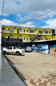 um camião branco estacionado em frente a um edifício amarelo em Kitinete em Chapecó