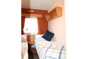 a small room with a couch and a window at 6-8 sleeper caravan Trecco Bay essentials included in Porthcawl