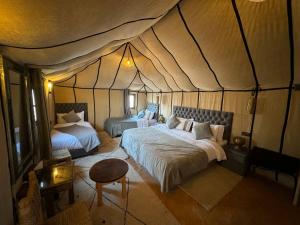 a bedroom with two beds in a tent at Merzouga Stars Luxury Camp in Merzouga