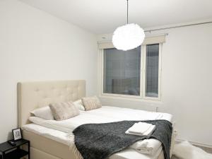 ロヴァニエミにあるCozy City Apartmentの白いベッドルーム(大きな窓付きのベッド付)