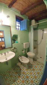 een badkamer met een wastafel, een toilet en een spiegel bij Villetta Costanza, Salina Isole Eolie in Rinella