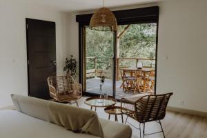 a living room with a couch and chairs and a patio at Côte & Lodge in Talais