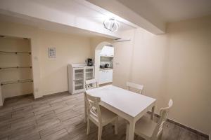eine Küche und ein Esszimmer mit einem weißen Tisch und Stühlen in der Unterkunft Gogol Apartment in Szeged