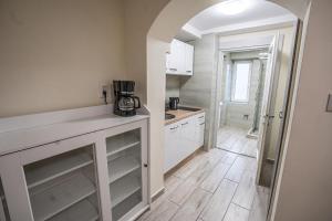 eine Küche mit weißen Schränken und einer Arbeitsplatte in der Unterkunft Gogol Apartment in Szeged