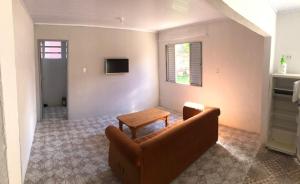 ein Wohnzimmer mit einem Sofa und einem Tisch in der Unterkunft Casa com 2 quartos grandes a 150m da praia in Rio Grande