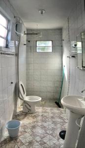 a bathroom with a toilet and a sink at Casa com 2 quartos grandes a 150m da praia in Rio Grande