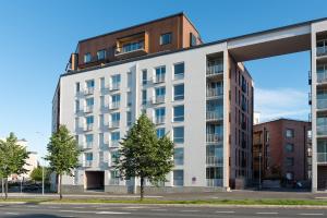 a large white building with a tree in front of it at Holiday Apartment Aava 2 in Rovaniemi