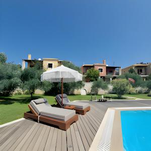 a deck with two lounge chairs and an umbrella and a pool at Alkyon Villas in Syvota