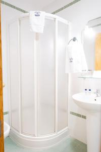 a white bathroom with a shower and a sink at Hotel Isla Menor in Dos Hermanas